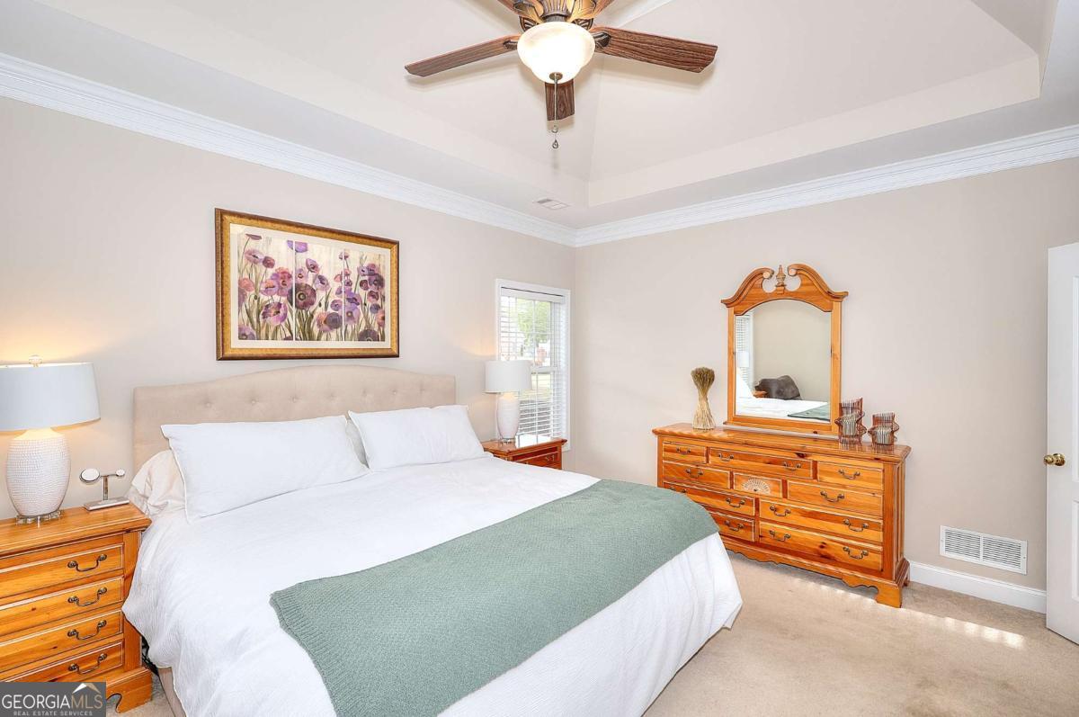 2385 Amberbrook Lane Grayson, GA 30017 - Photo 21 of 57 a bedroom with a bed and a chandelier