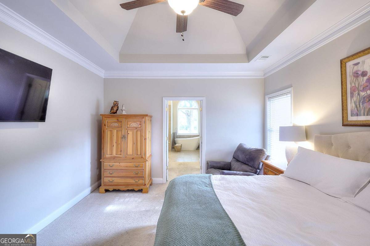 2385 Amberbrook Lane Grayson, GA 30017 - Photo 23 of 57 a bedroom with a bed and a chandelier