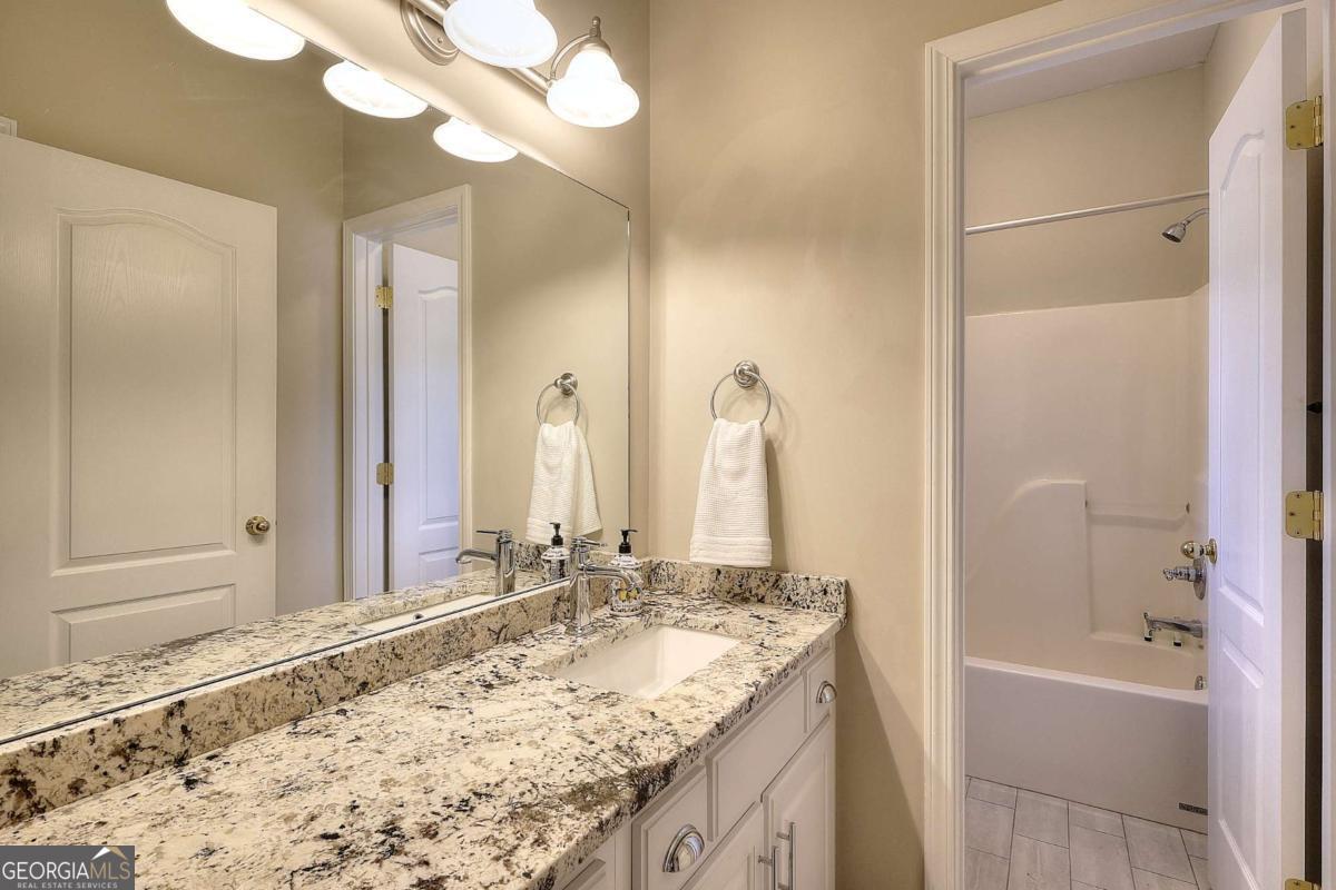 2385 Amberbrook Lane Grayson, GA 30017 - Photo 34 of 57 a bathroom with a granite countertop sink and a mirror