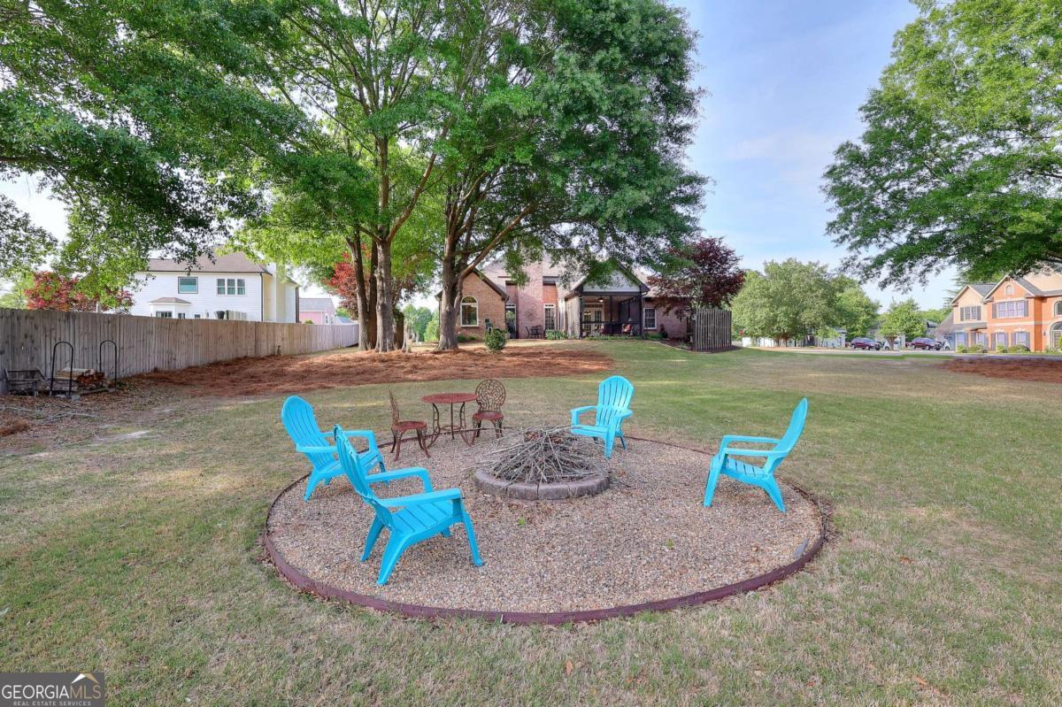 2385 Amberbrook Lane Grayson, GA 30017 - Photo 45 of 57 a view of a backyard with table and chairs potted plants and tree
