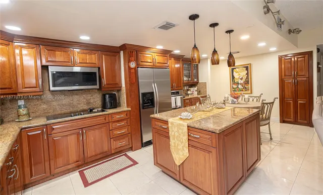 a kitchen with stainless steel appliances kitchen island granite countertop a sink and cabinets
