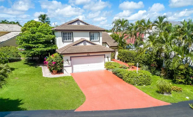 a front view of a house with a yard and potted plants