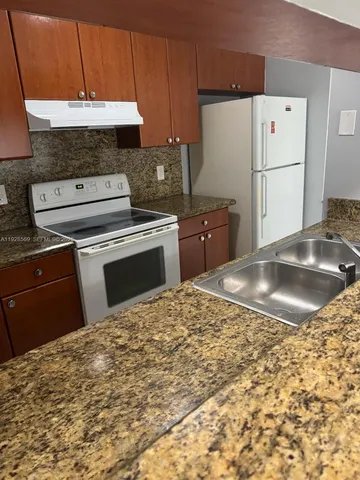 a kitchen with a stove a refrigerator and a sink