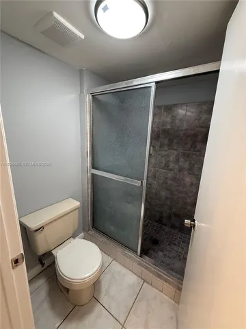 a bathroom with a toilet and a shower