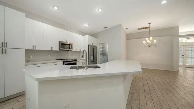 a kitchen with a sink appliances and cabinets