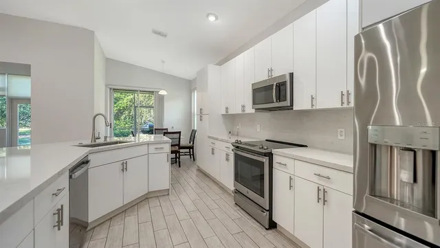 a kitchen with a sink a refrigerator and a stove top oven