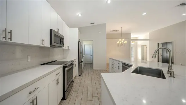 an empty room with wooden floor closet and windows