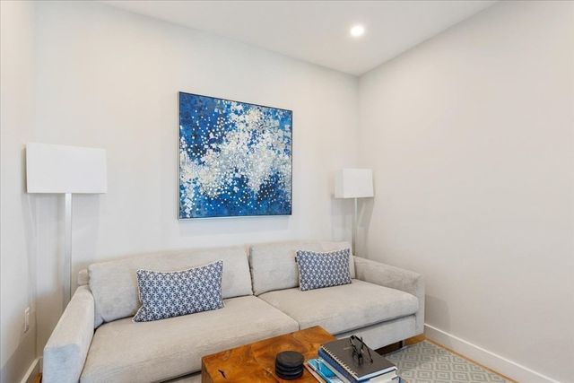 a living room with furniture and a wall painting