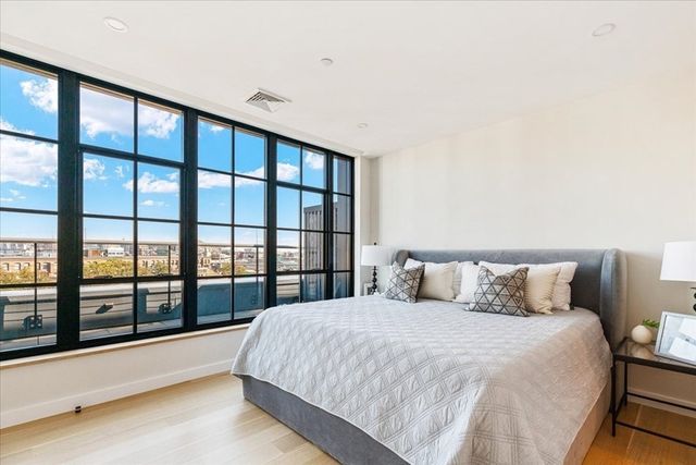 a large bed sitting in a bedroom next to a large window