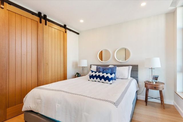 a bedroom with a bed and a potted plant next to a window