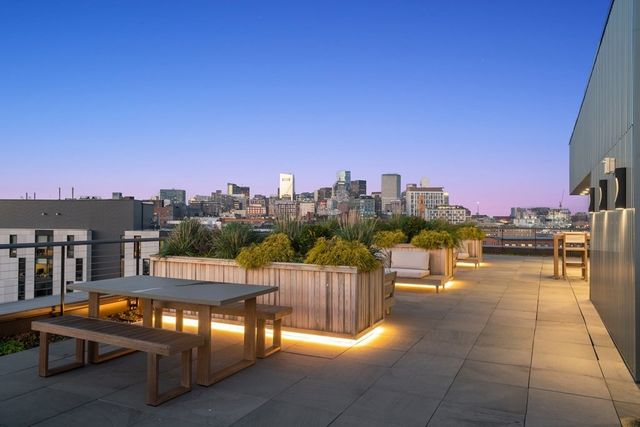 a view of a roof deck with couches and sky view