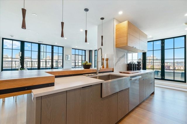 a large kitchen with stainless steel appliances lots of counter space and a sink