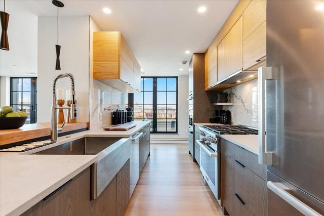 a large kitchen with stainless steel appliances granite countertop a lot of counter space and a sink