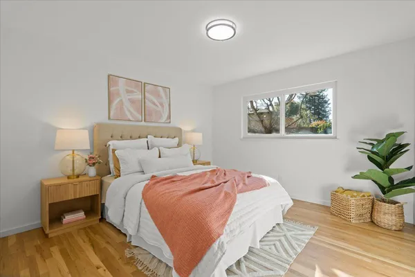 a bedroom with two beds and a painting on the wall