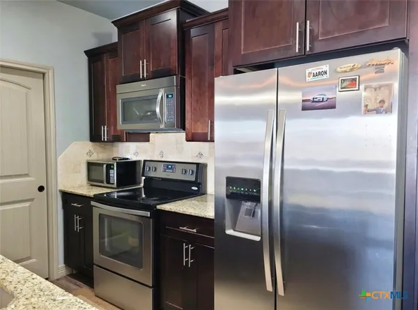 a kitchen with refrigerator and island