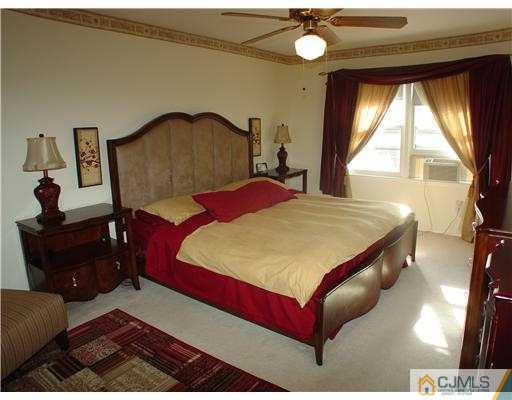 17 Sinclair Road Edison, NJ 08820 - Photo 7 of 11 a bedroom with a bed and a dresser next to a window