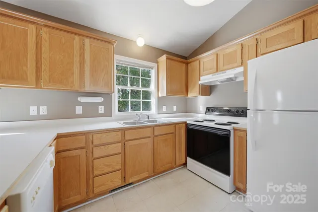a kitchen with stainless steel appliances granite countertop a stove a sink and a refrigerator