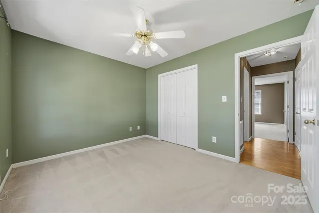 a view of an empty room with a chandelier fan