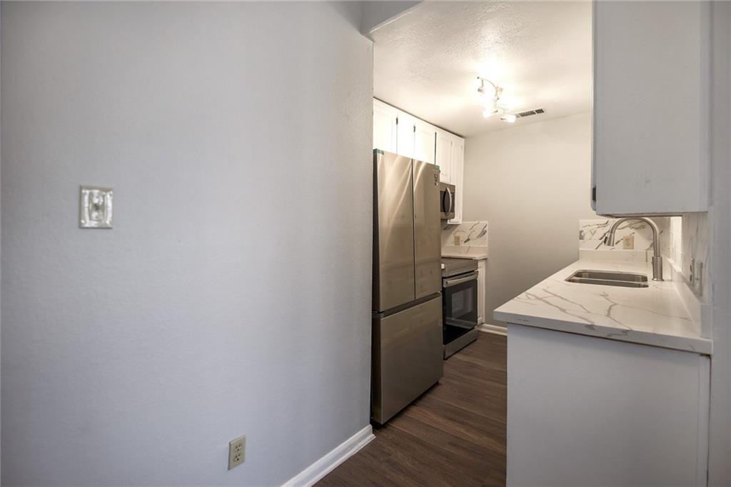 2529 Rio Grande Street, Unit 93 Austin, TX 78705 - Photo 3 of 19 The kitchen features stainless steel appliances, white cabinetry, a sink with a modern faucet, and countertops with a marble-like pattern