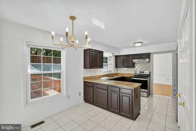 a kitchen with stainless steel appliances granite countertop a stove and a sink