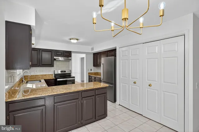 a kitchen with stainless steel appliances granite countertop a refrigerator a sink and dishwasher