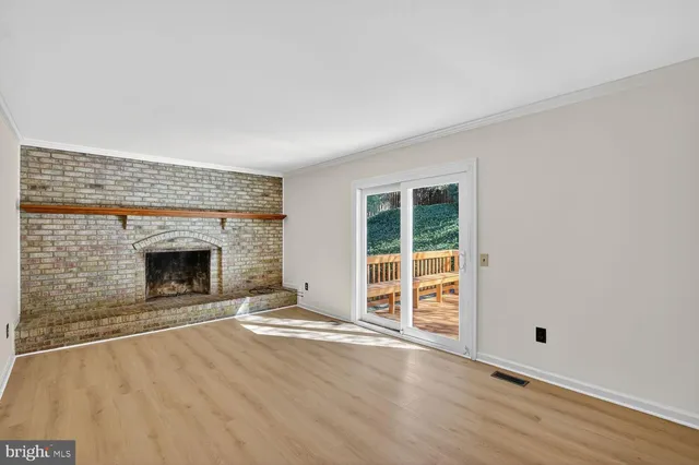 an empty room with floor to ceiling window and fireplace