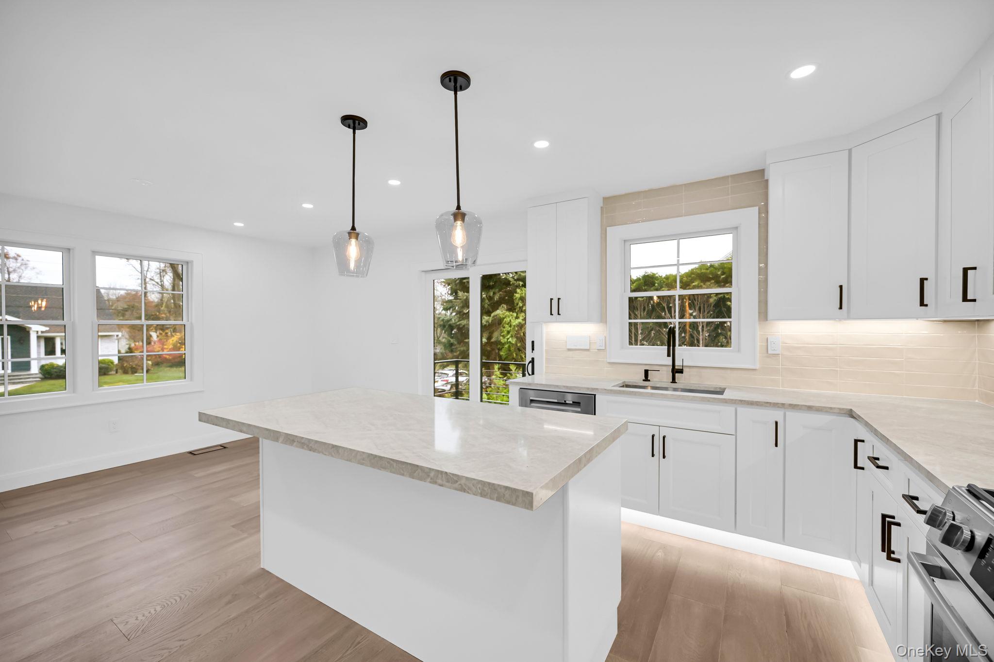 82 Seton Drive New Rochelle, NY 10804 - Photo 17 of 50 a large kitchen with stainless steel appliances a large counter top a sink a window and wooden floor