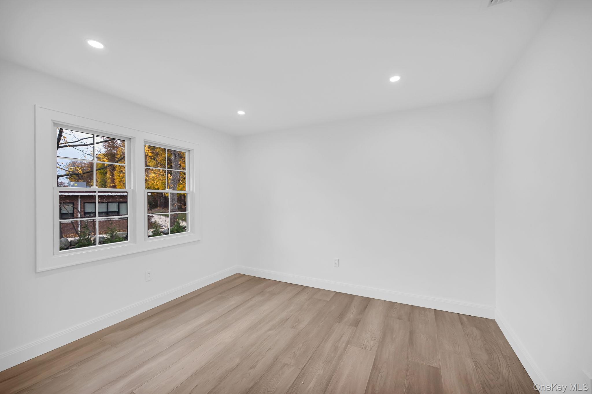 82 Seton Drive New Rochelle, NY 10804 - Photo 23 of 50 an empty room with wooden floor and windows
