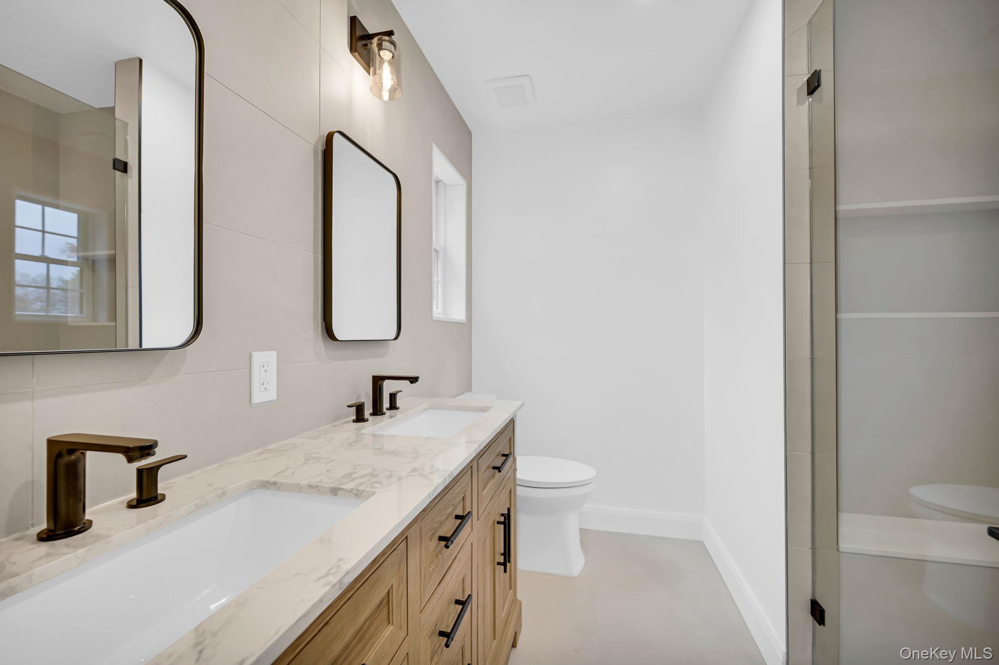 82 Seton Drive New Rochelle, NY 10804 - Photo 31 of 50 a bathroom with a double vanity sink toilet and mirror