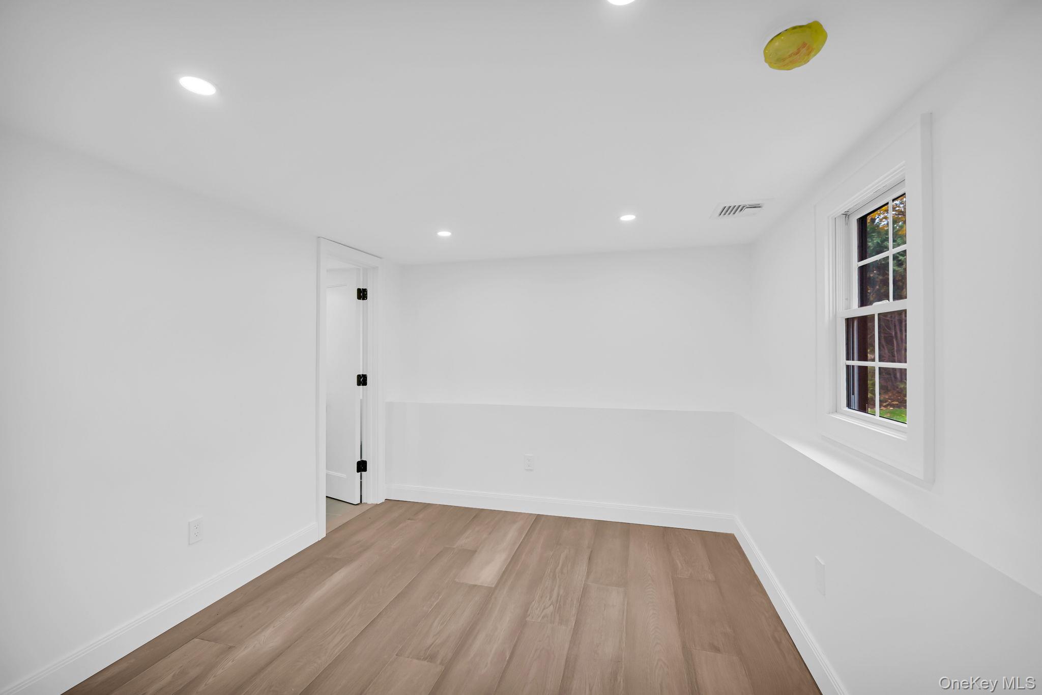 82 Seton Drive New Rochelle, NY 10804 - Photo 38 of 50 a view of an empty room with wooden floor and a window