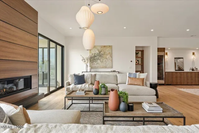 a living room with furniture wooden floor and kitchen view