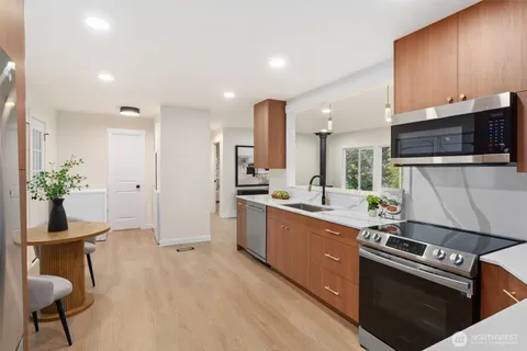 a kitchen with stainless steel appliances kitchen island granite countertop a stove a sink and a microwave