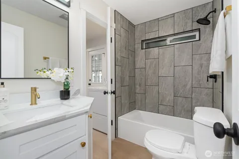 a bathroom with a sink a toilet a mirror and shower