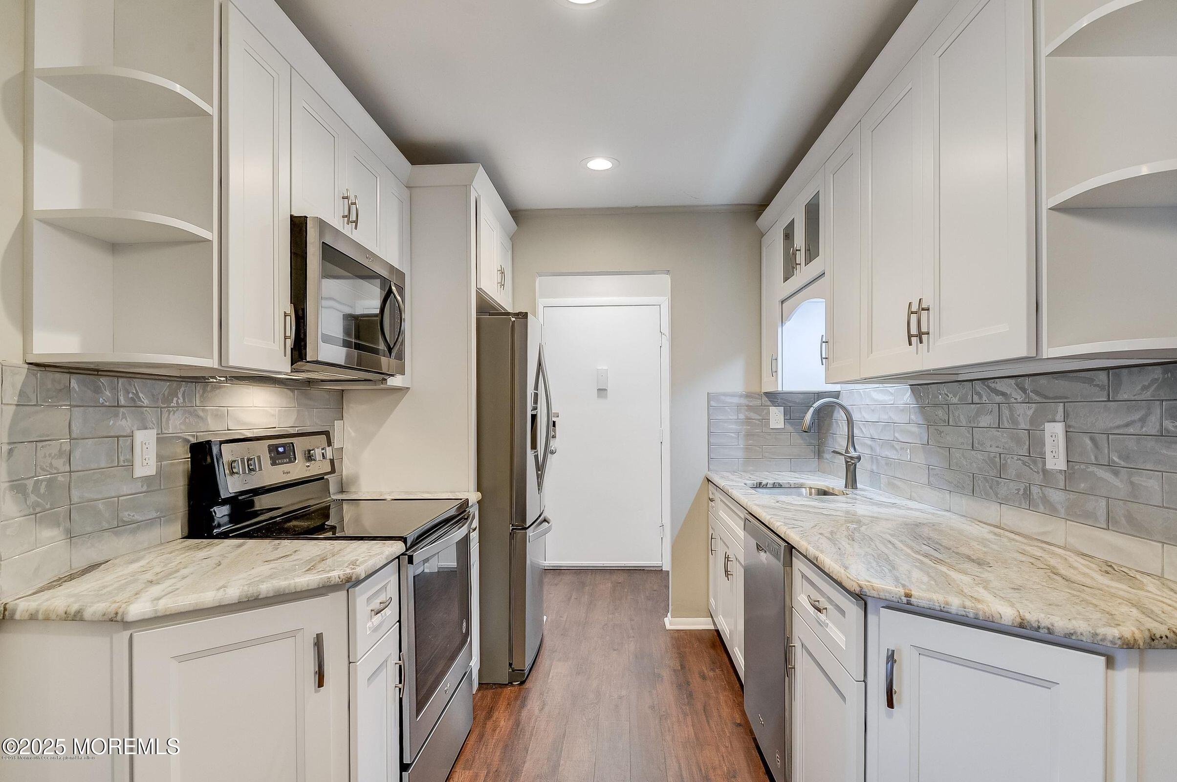 97 Arrowood Road, Unit K Manalapan, NJ 07726 - Photo 3 of 29 a kitchen with stainless steel appliances granite countertop a sink stove and refrigerator