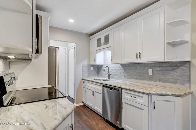 a kitchen with a sink a refrigerator and cabinets