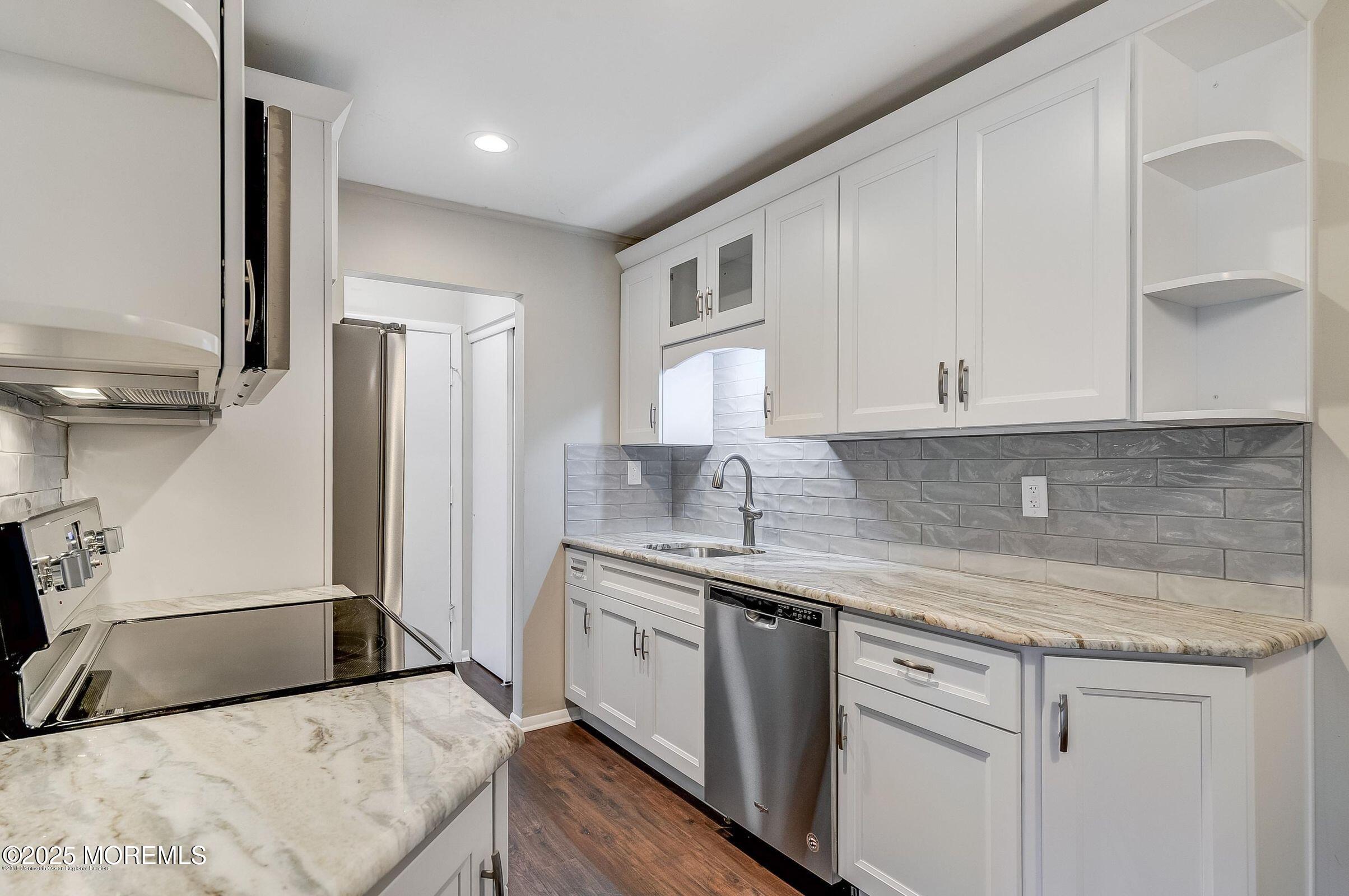 97 Arrowood Road, Unit K Manalapan, NJ 07726 - Photo 4 of 29 a kitchen with a sink a refrigerator and cabinets