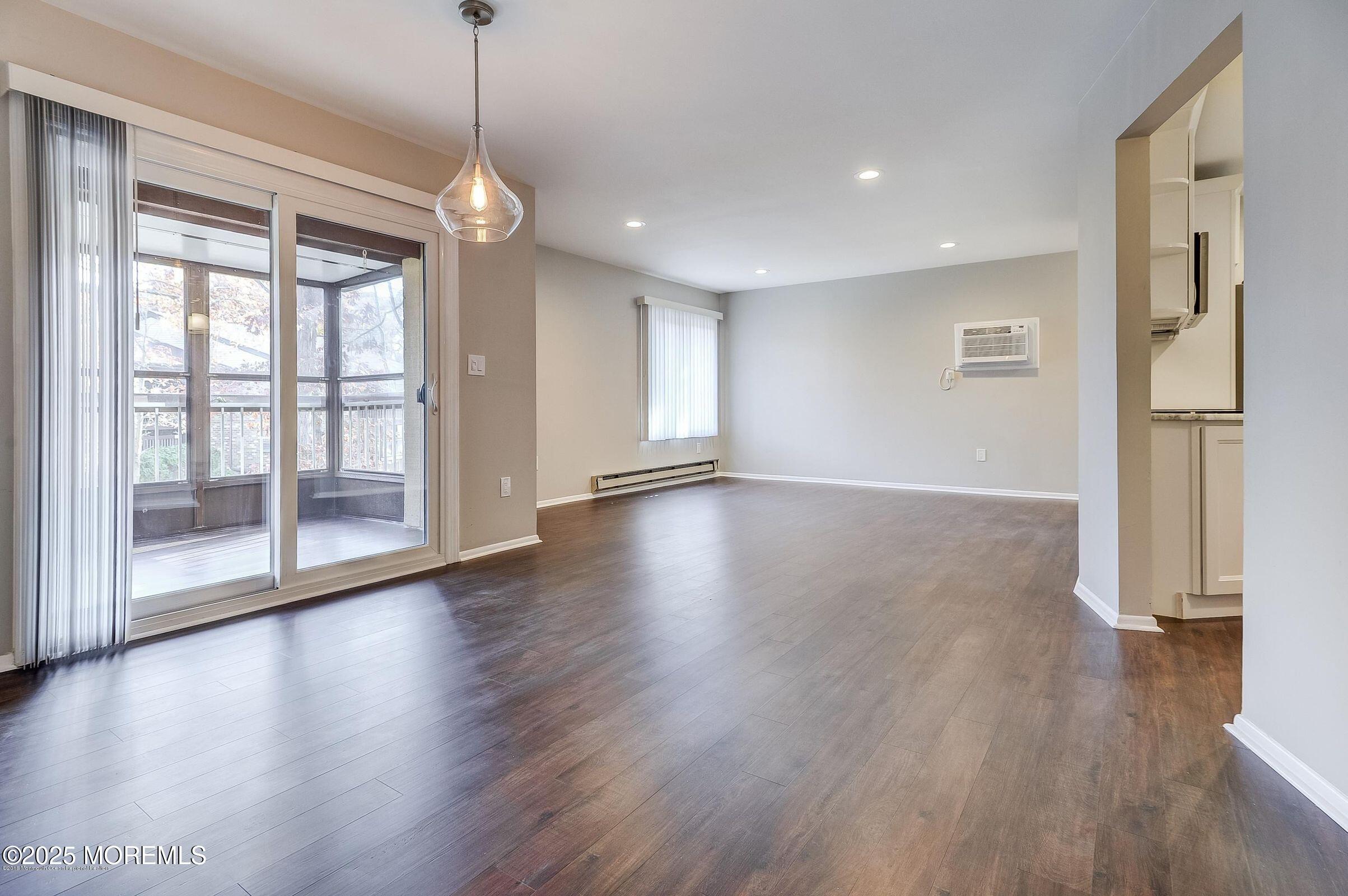 97 Arrowood Road, Unit K Manalapan, NJ 07726 - Photo 7 of 29 a view of an empty room with wooden floor and a window