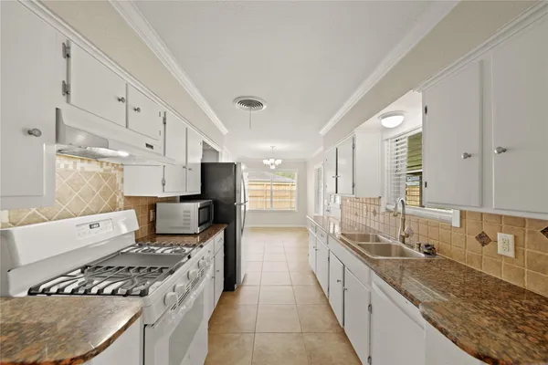 a large kitchen with stainless steel appliances granite countertop a lot of counter space and wooden floors