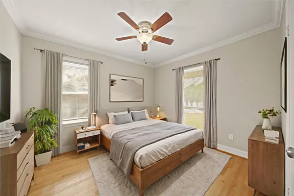 a bedroom with a bed and a large window with potted plants