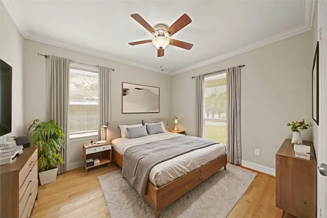 a bedroom with a bed and a large window with potted plants
