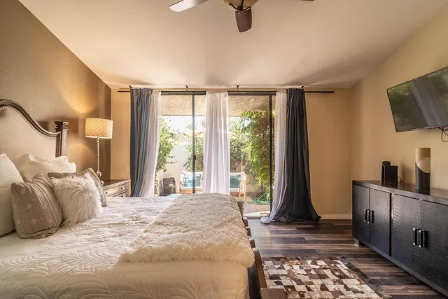 a view of a patio with table and chairs potted plants and palm tree