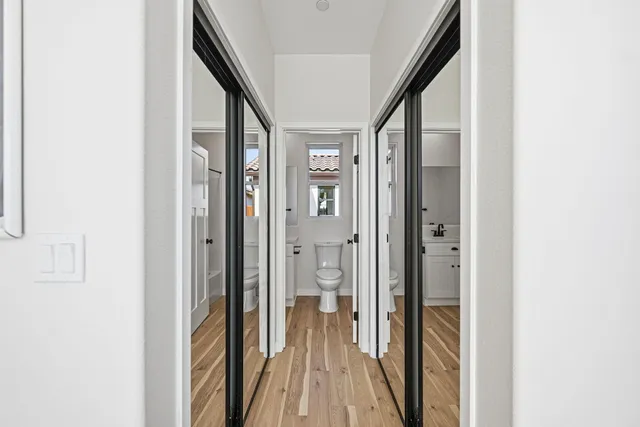 a view of a hallway with wooden floor and staircase