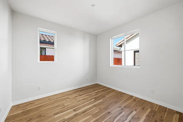 a view of a room with wooden floor and window