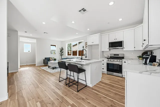 a kitchen with a sink a counter top space stainless steel appliances and cabinets