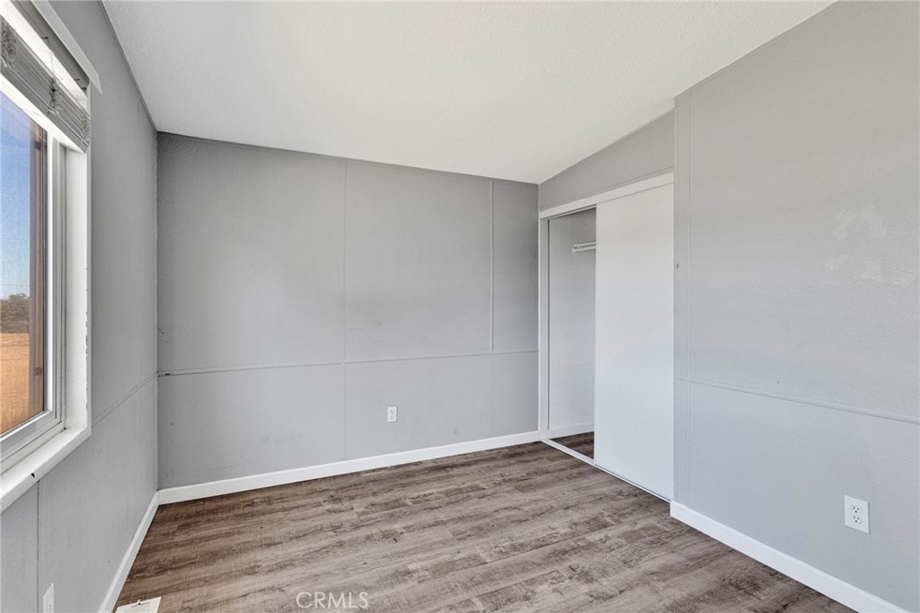 8074 Mira Mar Road Phelan, CA 92371 - Photo 23 of 49 a view of an empty room with wooden floor and a window