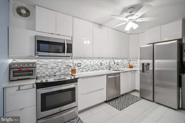 a kitchen with granite countertop stainless steel appliances a stove microwave and sink