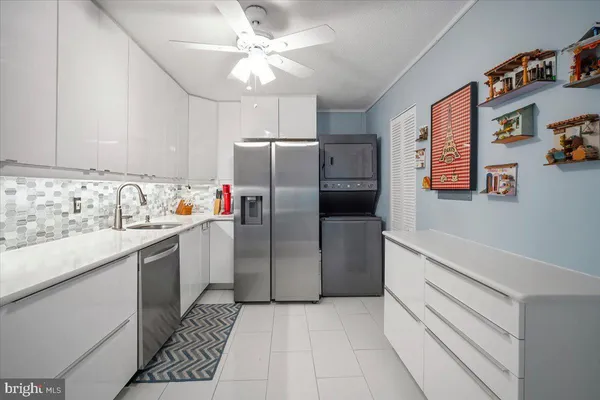 a kitchen with stainless steel appliances a refrigerator sink and white cabinets