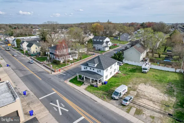 an aerial view of a city with lots of residential buildings ocean and mountain view in back