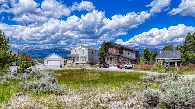 a view of a house with a big yard and large trees