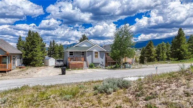 a front view of a house with a yard and car parked
